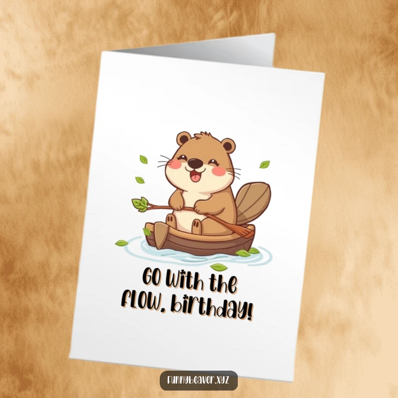 Funny free printable birthday card showing a happy beaver paddling a leaf raft, perfect for a cheerful DIY gift.